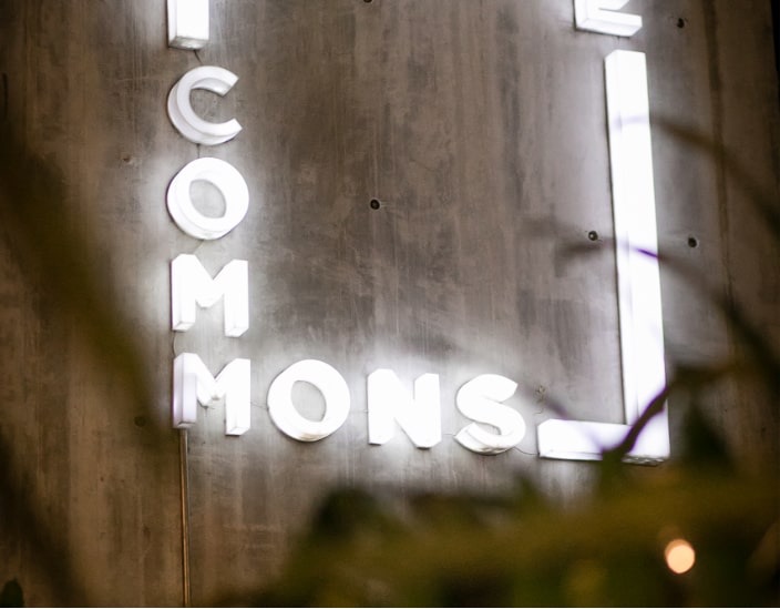 コンクリート壁の theCOMMONS の電飾看板
